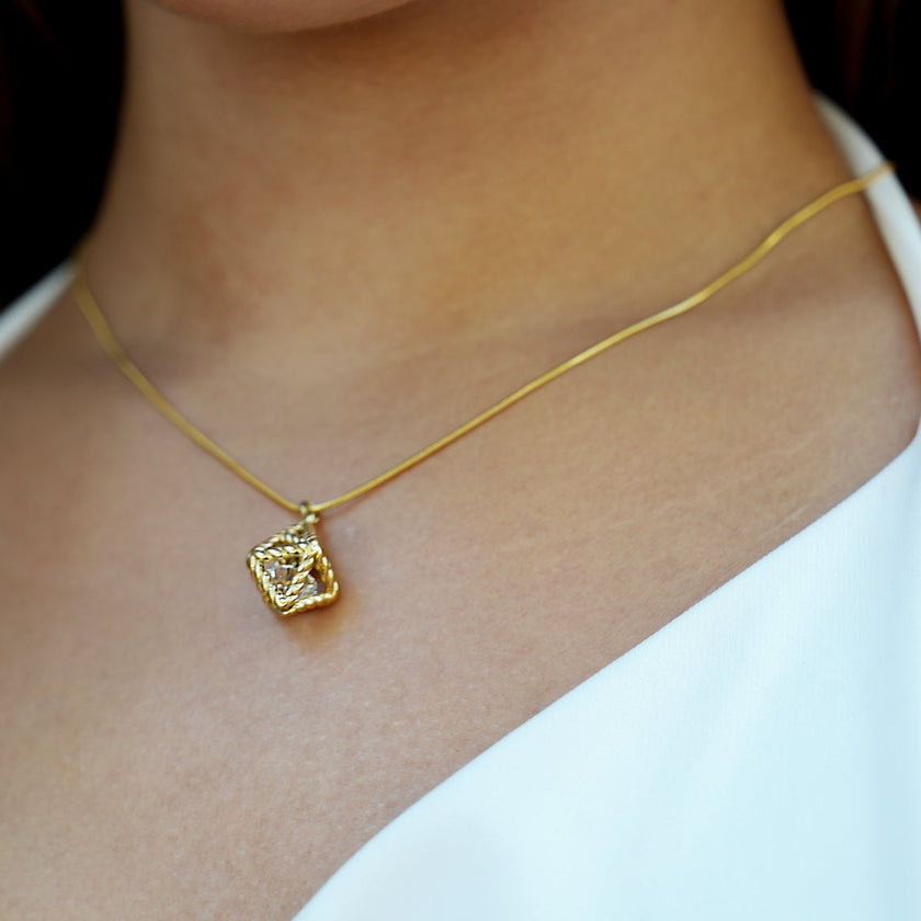 Style KARJAT : Collier à chaîne dorée avec pendentif en zircone géométrique en cage.