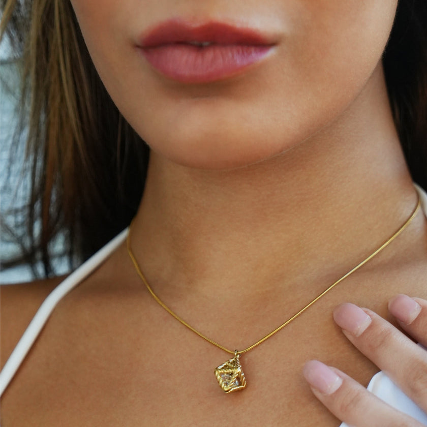 Style KARJAT : Collier à chaîne dorée avec pendentif en zircone géométrique en cage.