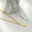 Style KORATIA : Collier minimaliste avec chaîne à maillons plats et pendentif barre en or incrusté de zircone.