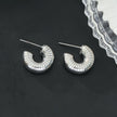KOTOHIRA : Boucles d'oreilles créoles tubulaires à surface texturée, effet creux et volumineux, en or blanc argenté.