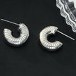 KOTOHIRA : Boucles d'oreilles créoles tubulaires à surface texturée, effet creux et volumineux, en or blanc argenté.