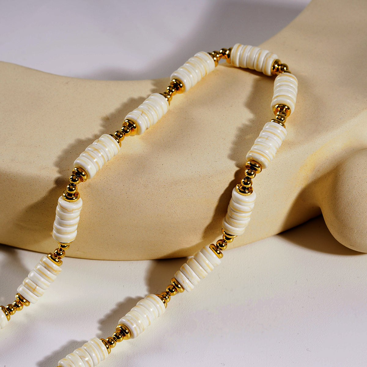 LULAMA : Collier bohème moderne en chaîne avec pierres de turquoise blanche et perles dorées.