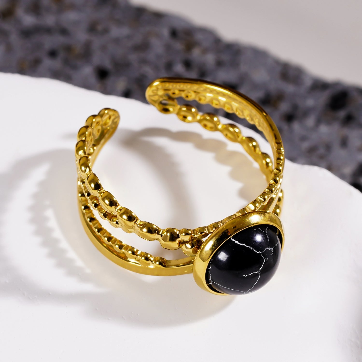 MALAYA : Bague à plusieurs anneaux entrelacés avec une pierre centrale de turquoise noire.
