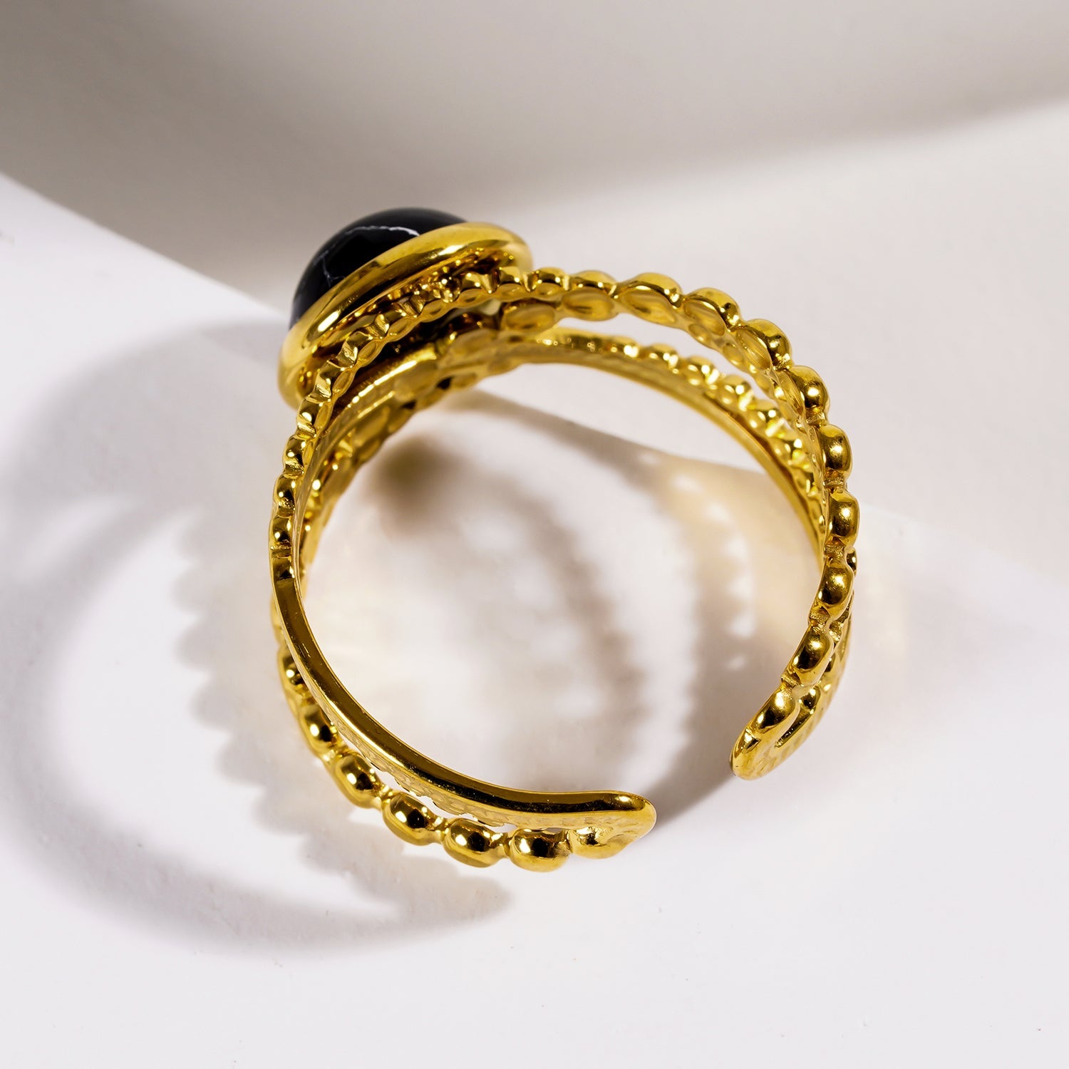 MALAYA : Bague à plusieurs anneaux entrelacés avec une pierre centrale de turquoise noire.