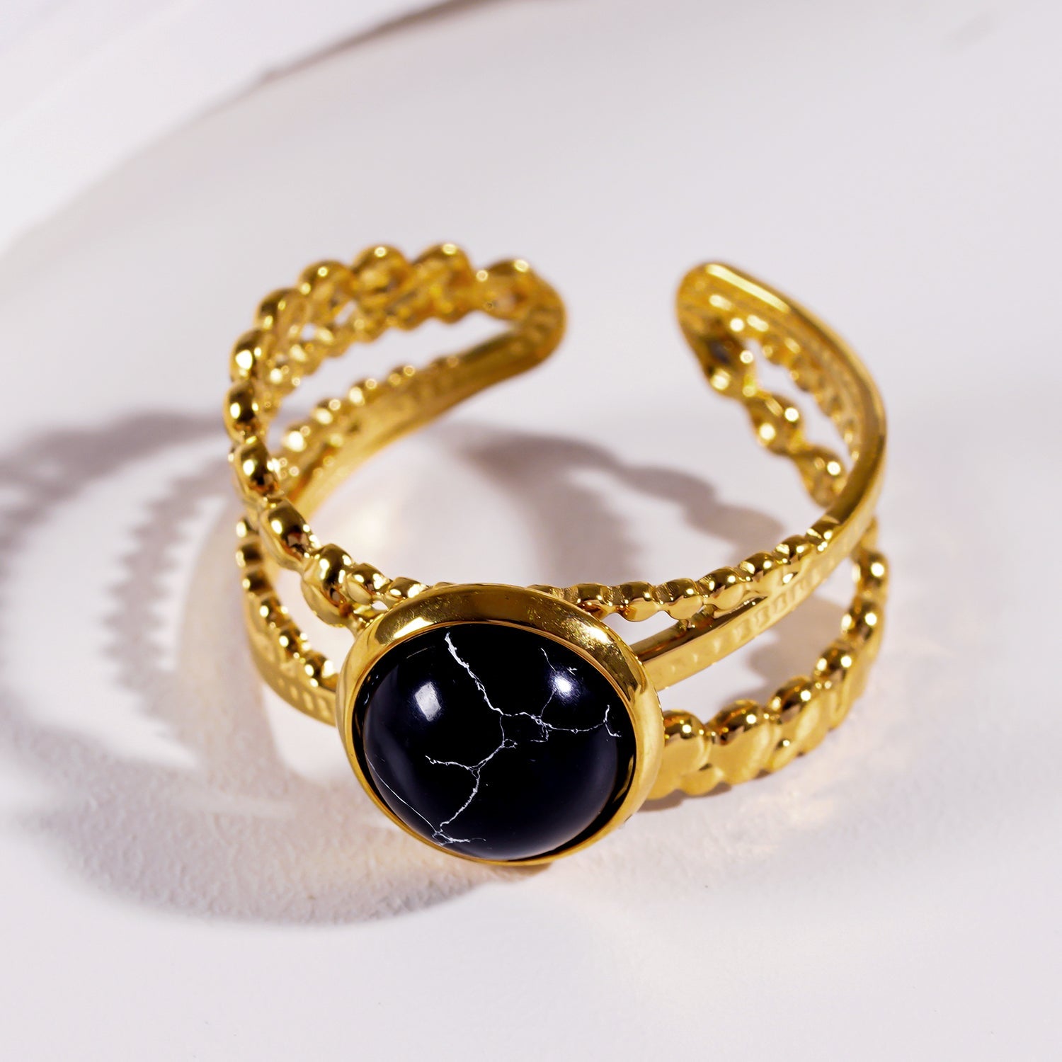 MALAYA : Bague à plusieurs anneaux entrelacés avec une pierre centrale de turquoise noire.