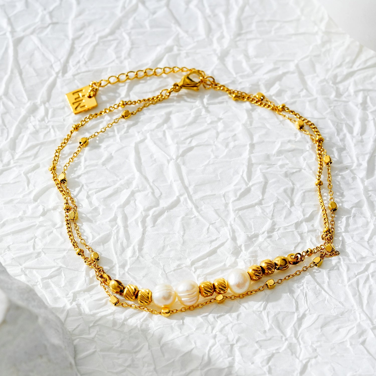 Style MARENTA LG : Bracelet de cheville en chaîne dorée avec perles dorées et perles d'eau douce.