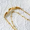 Style MARENTA LG : Bracelet de cheville en chaîne dorée avec perles dorées et perles d'eau douce.