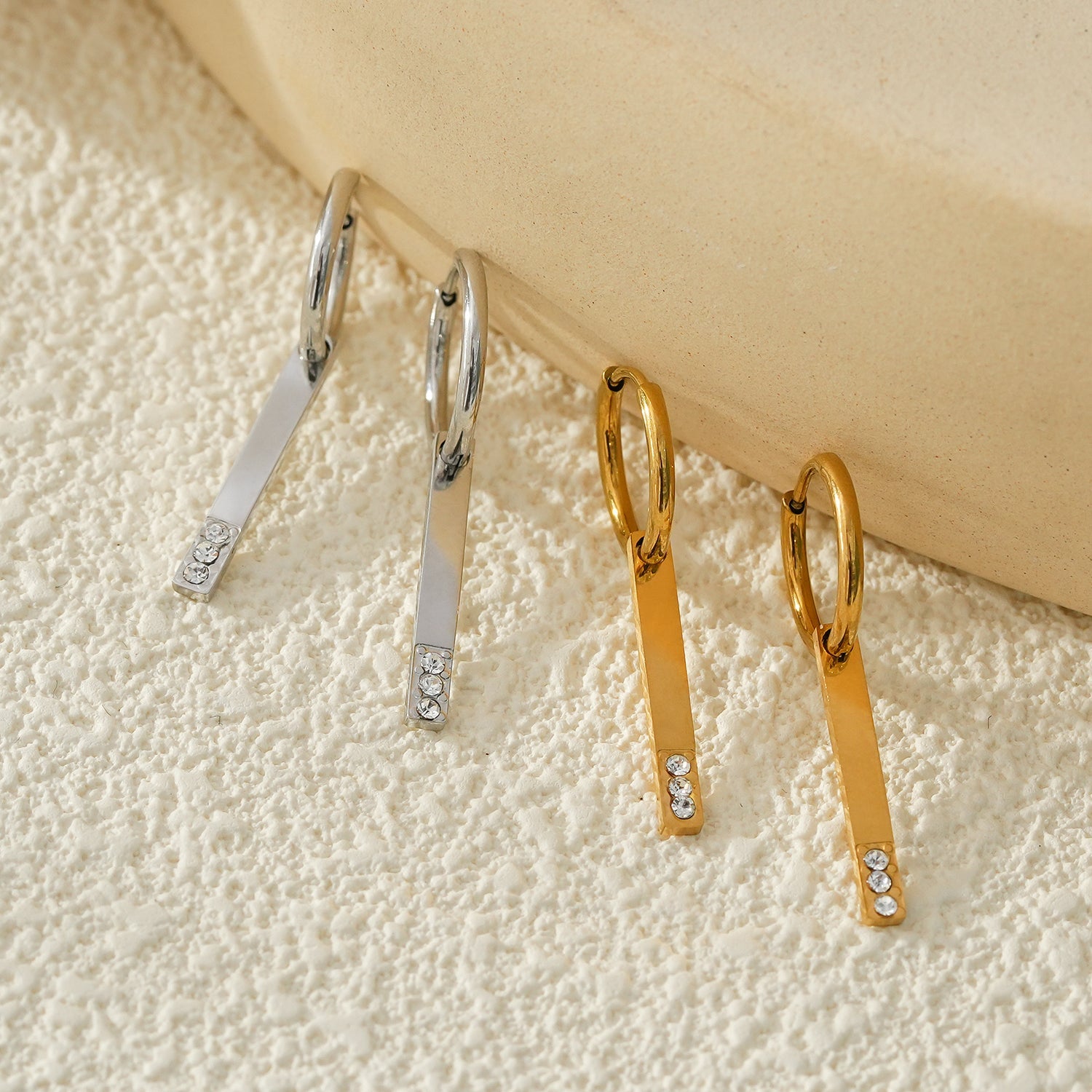 Style MAYLA : Boucles d’oreilles dorées avec un charme minimaliste mettant en valeur un trio de pierres précieuses en zircone.