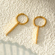 Style MAYLA : Boucles d’oreilles dorées avec un charme minimaliste mettant en valeur un trio de pierres précieuses en zircone.