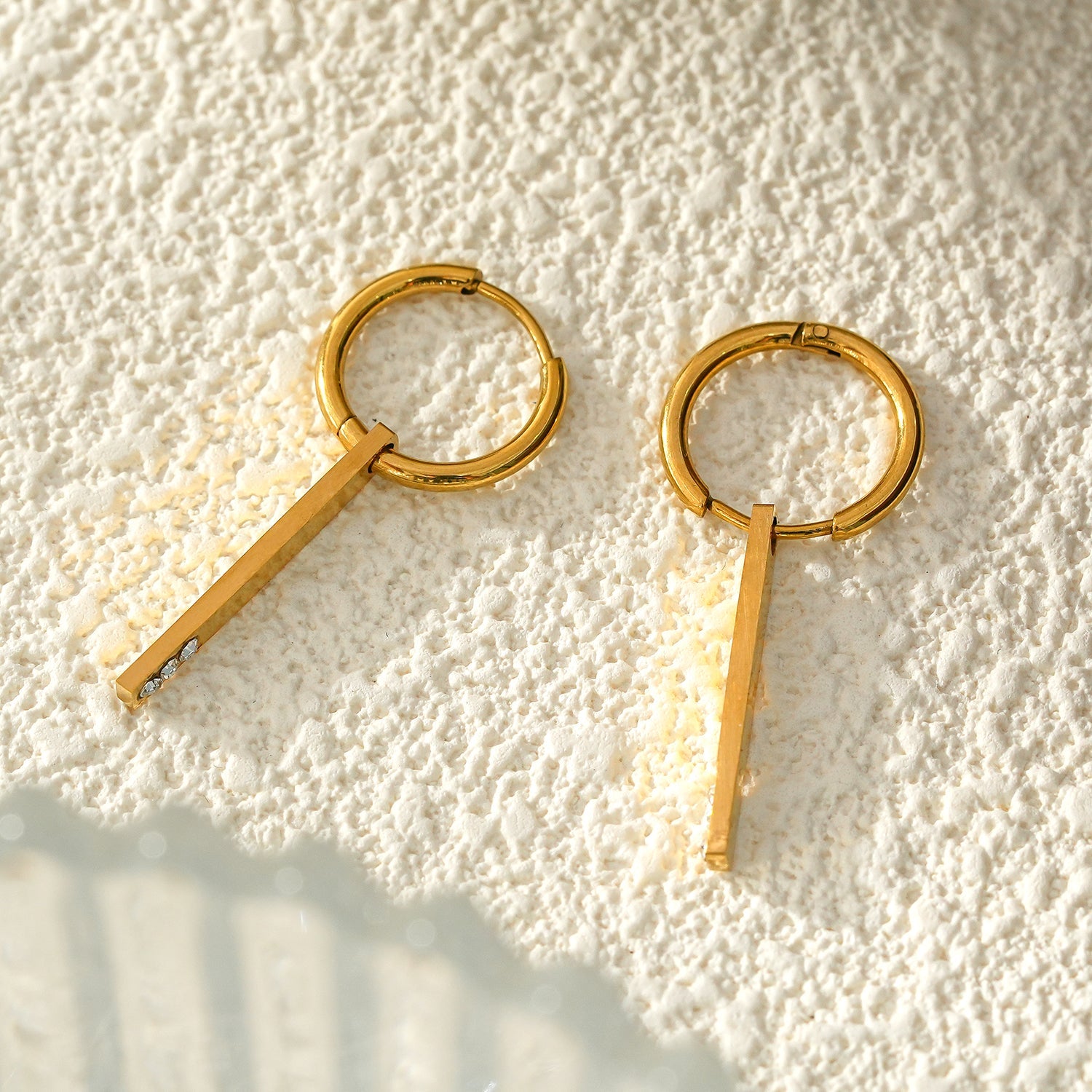 Style MAYLA : Boucles d’oreilles dorées avec un charme minimaliste mettant en valeur un trio de pierres précieuses en zircone.