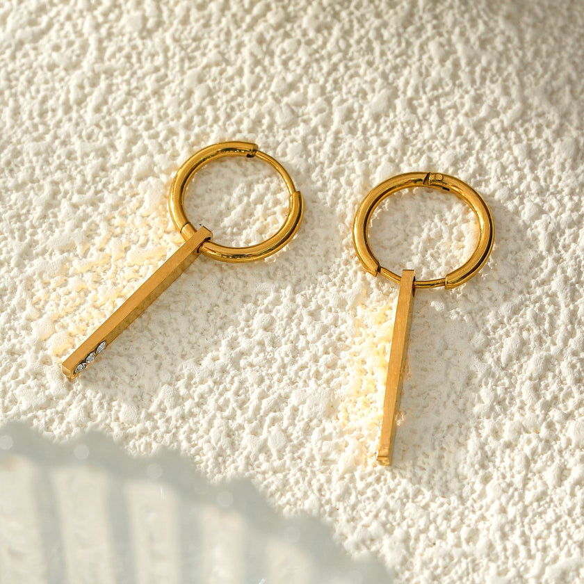 Style MAYLA : Boucles d’oreilles dorées avec un charme minimaliste mettant en valeur un trio de pierres précieuses en zircone.