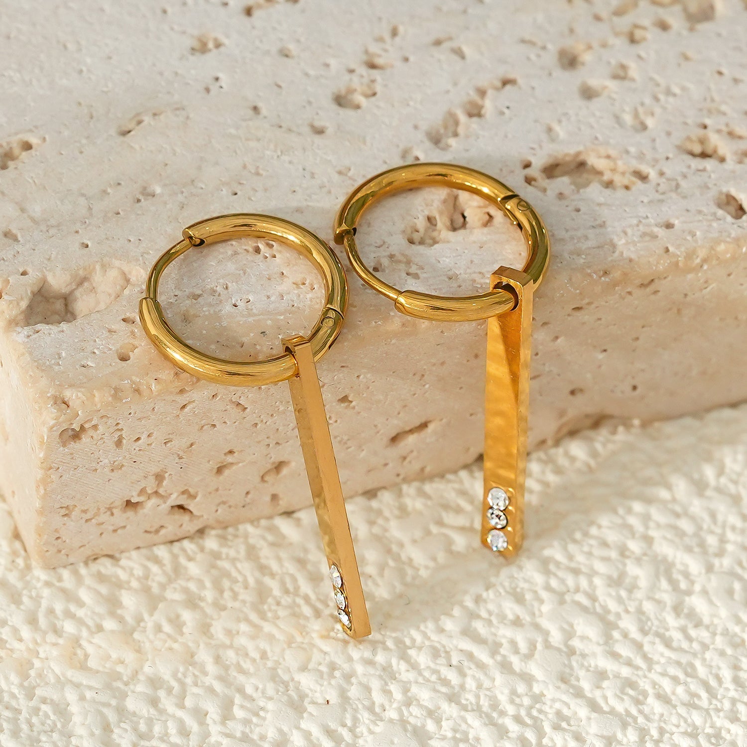 Style MAYLA : Boucles d’oreilles dorées avec un charme minimaliste mettant en valeur un trio de pierres précieuses en zircone.