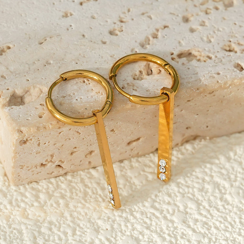 Style MAYLA : Boucles d’oreilles dorées avec un charme minimaliste mettant en valeur un trio de pierres précieuses en zircone.