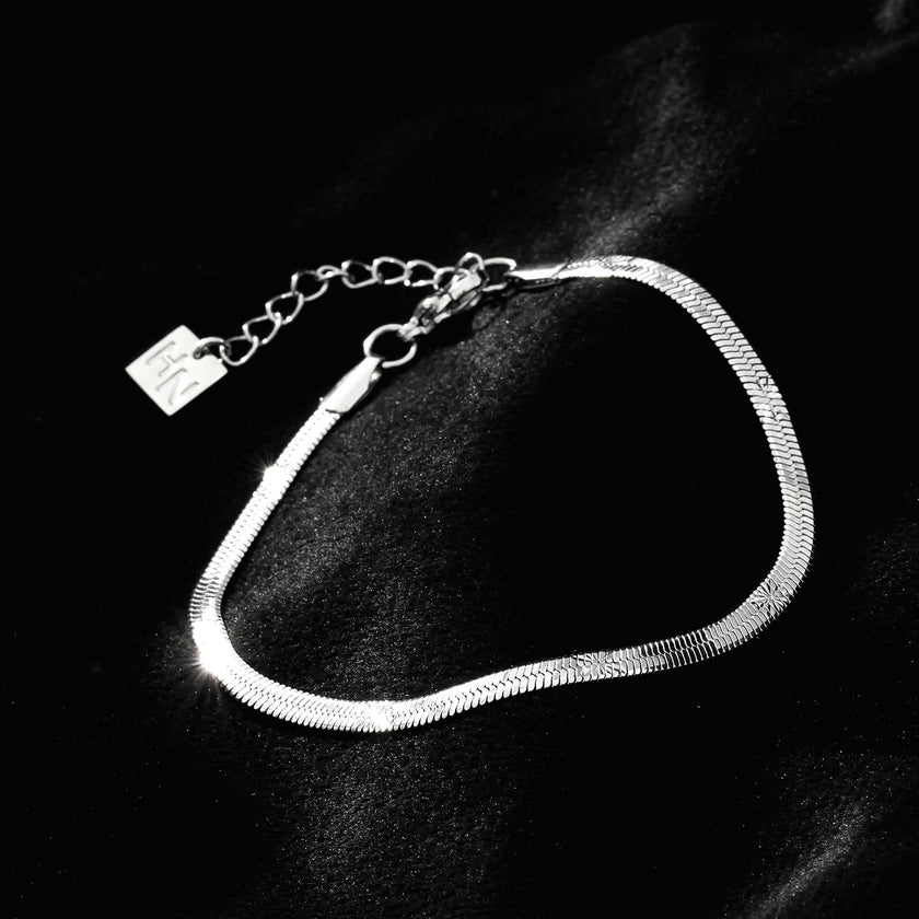MUKER : Bracelet en chaîne argentée texturée effet peau de serpent avec motif étoile en relief.