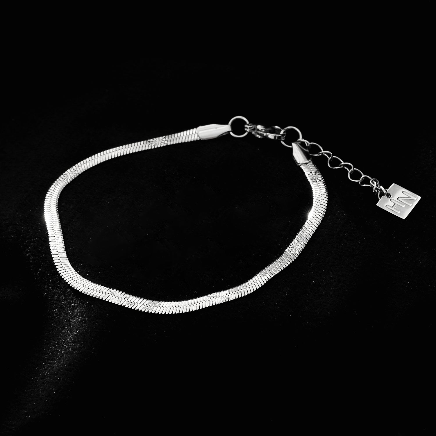 MUKER : Bracelet en chaîne argentée texturée effet peau de serpent avec motif étoile en relief.