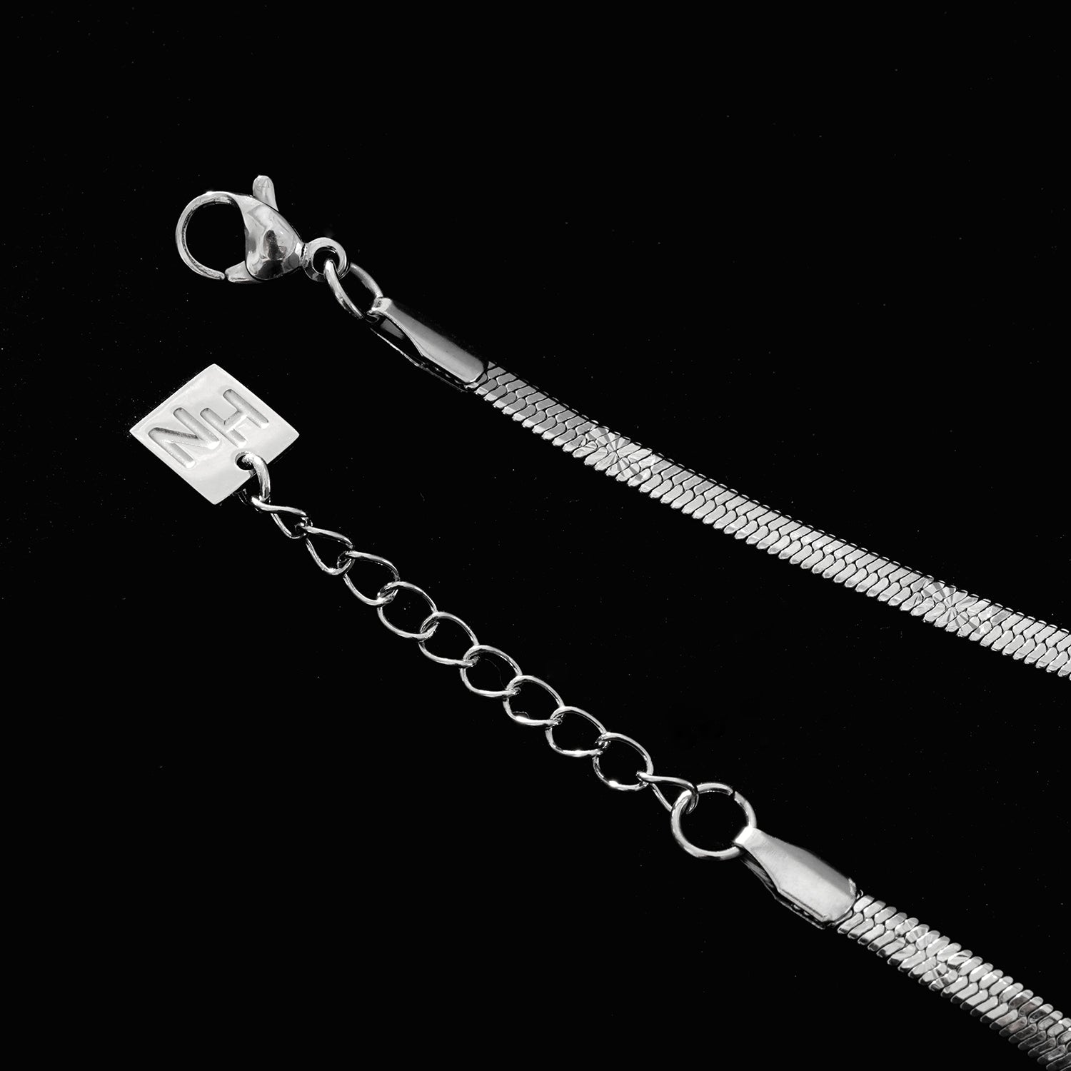 MUKER : Bracelet en chaîne argentée texturée effet peau de serpent avec motif étoile en relief.