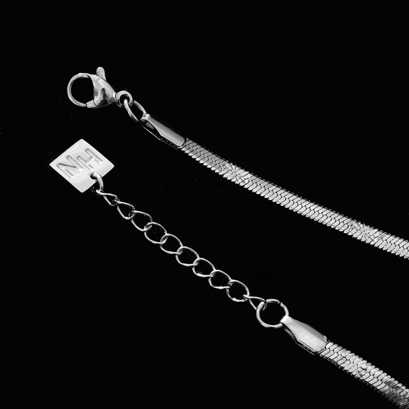MUKER : Bracelet en chaîne argentée texturée effet peau de serpent avec motif étoile en relief.
