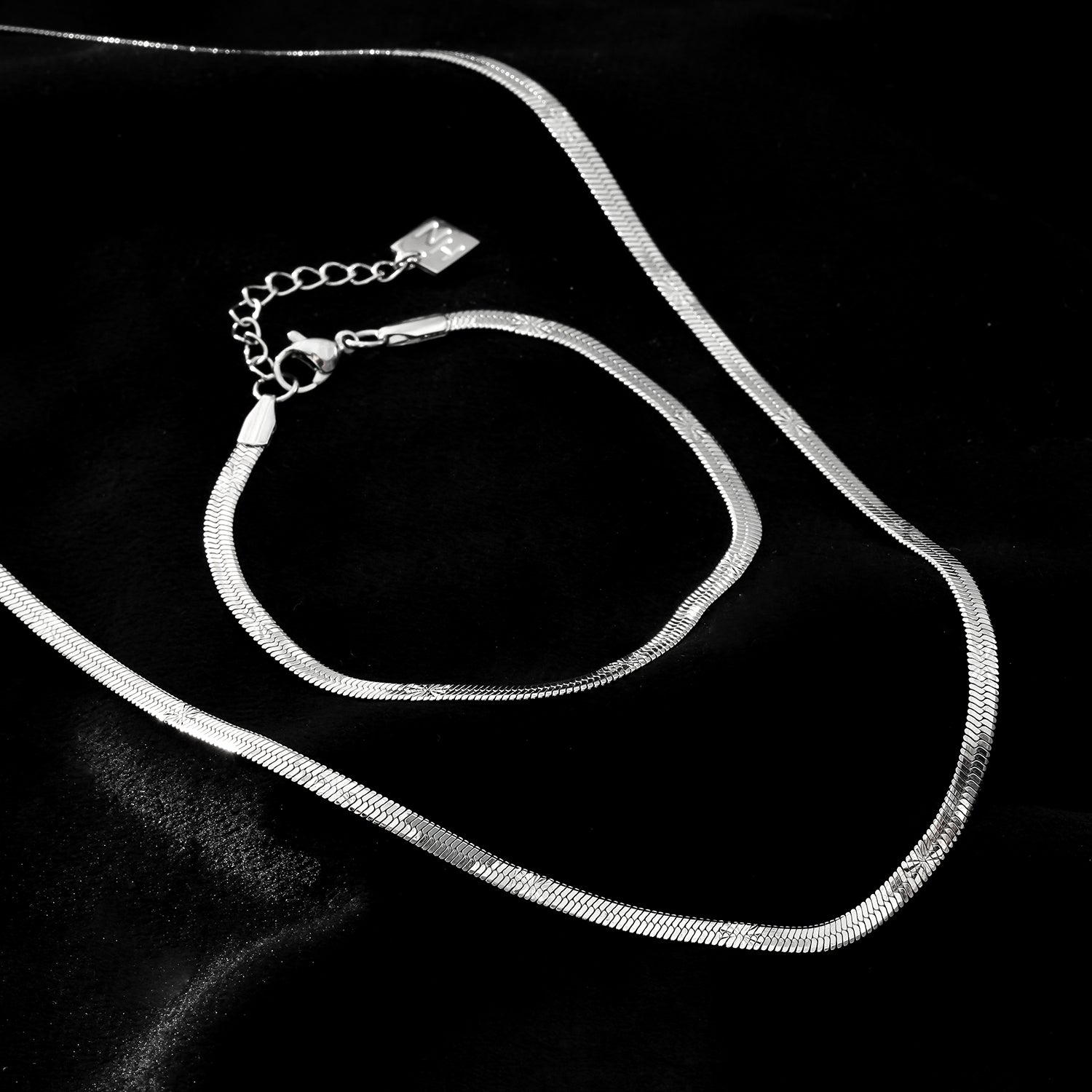 MUKER : Bracelet en chaîne argentée texturée effet peau de serpent avec motif étoile en relief.