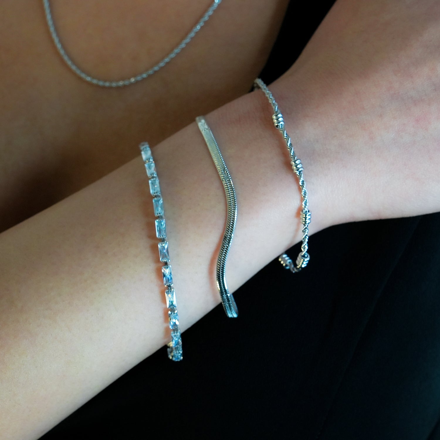 MUKER : Bracelet en chaîne argentée texturée effet peau de serpent avec motif étoile en relief.