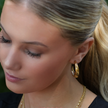 Boucles d'oreilles créoles dorées DORSINA à lignes texturées. Inspirées par la nature.