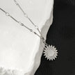 NOMIA Or Blanc (Couleur Argent) : Collier avec pendentif soleil rayonnant en zircone.