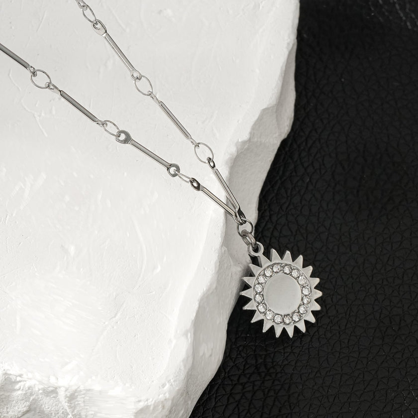 NOMIA Or Blanc (Couleur Argent) : Collier avec pendentif soleil rayonnant en zircone.