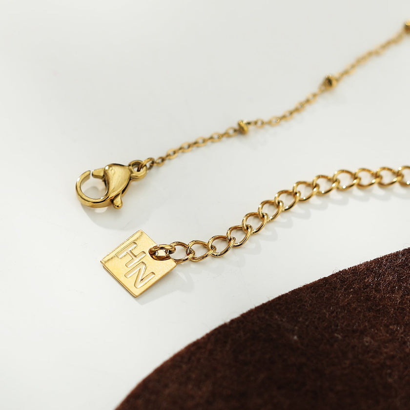 Chaîne dorée perlée KIMI avec pendentif en zircone pavé délicat.