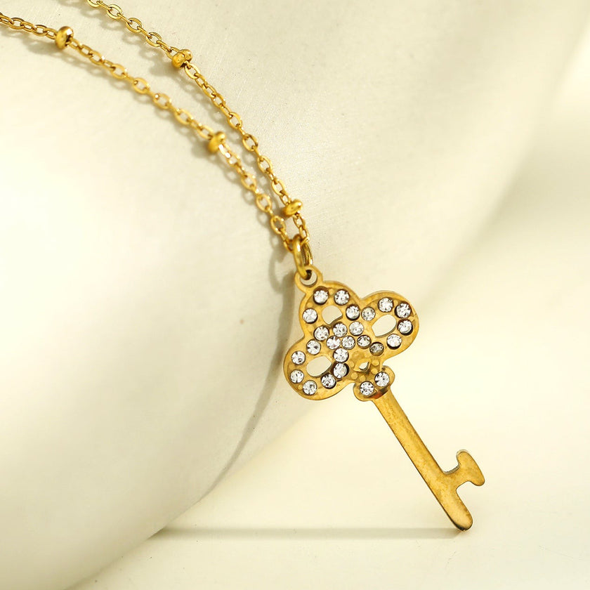 Collier UNLOK en or perlé avec pendentif clé orné de zircons.