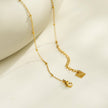 Collier UNLOK en or perlé avec pendentif clé orné de zircons.