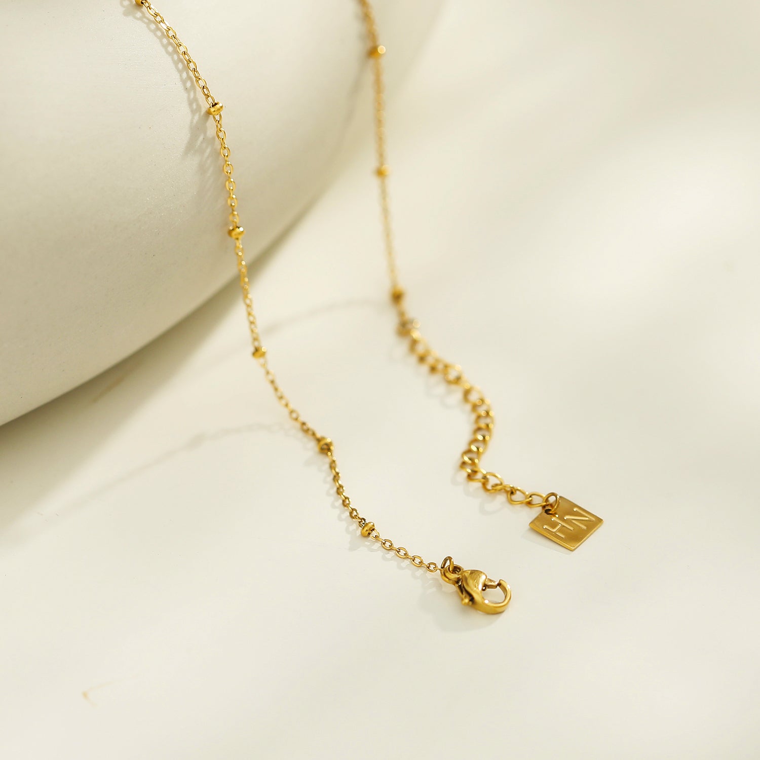 Collier UNLOK en or perlé avec pendentif clé orné de zircons.