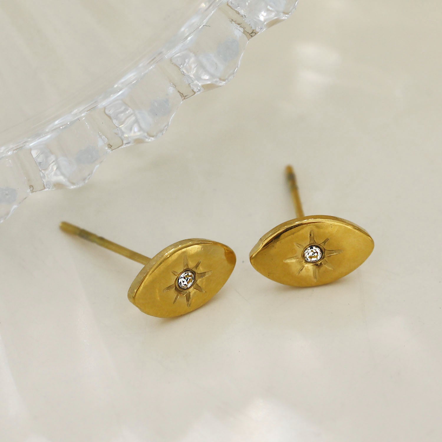 TINDRA : Boucles d'oreilles en forme d'ovale en or avec un zircon solitaire.