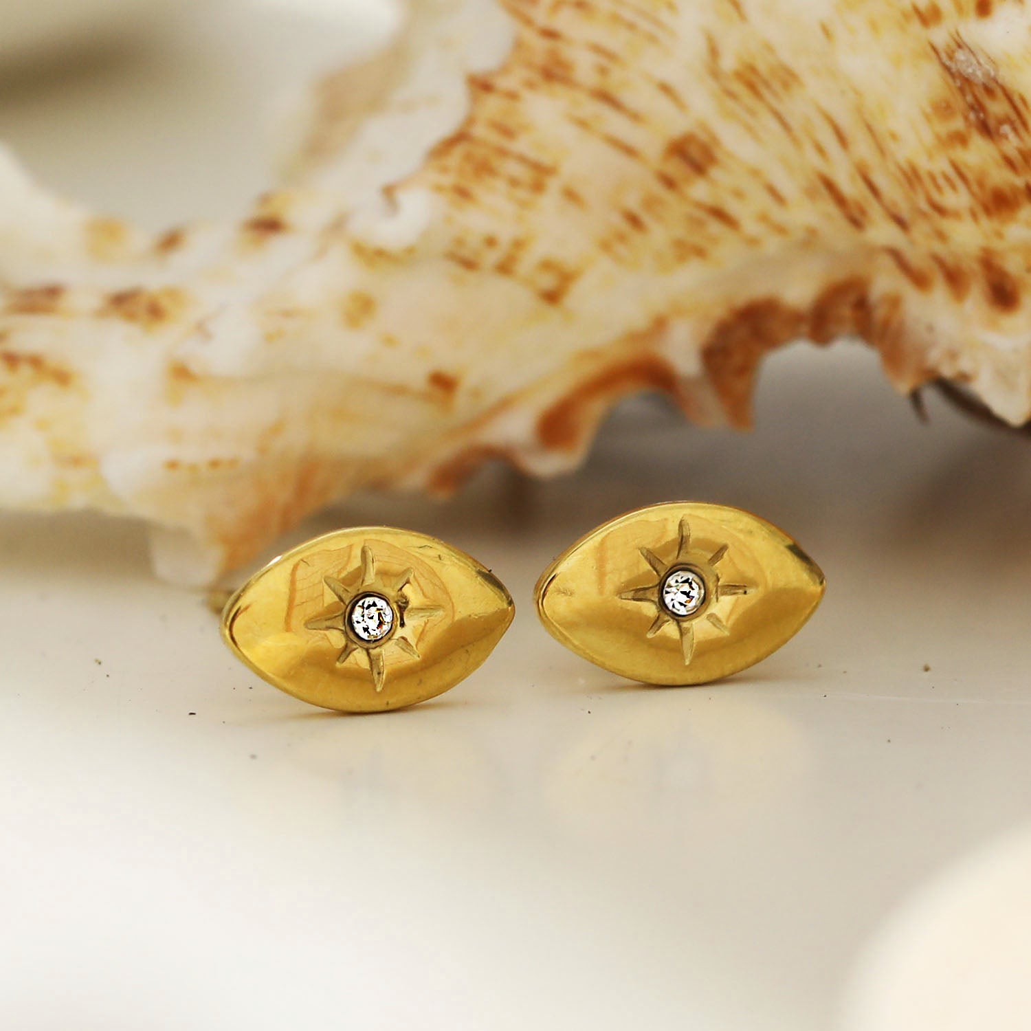 TINDRA : Boucles d'oreilles en forme d'ovale en or avec un zircon solitaire.