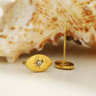 TINDRA : Boucles d'oreilles en forme d'ovale en or avec un zircon solitaire.