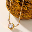 AURA : Collier avec pendentif en zircone serti dans un cadre sur une chaîne à perles de mini-zircone.