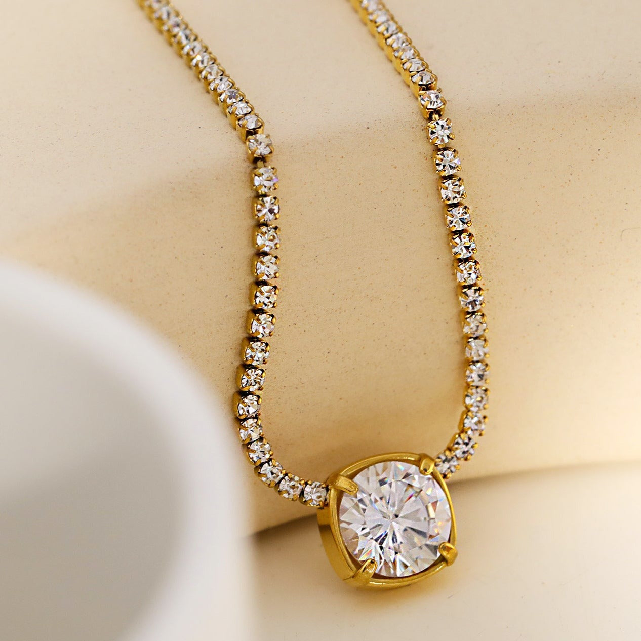 AURA : Collier avec pendentif en zircone serti dans un cadre sur une chaîne à perles de mini-zircone.