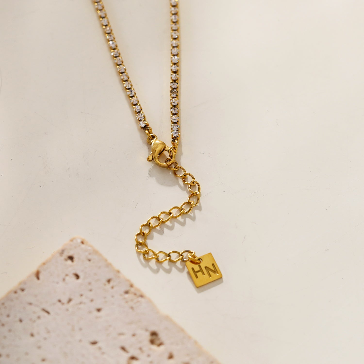 AURA : Collier avec pendentif en zircone serti dans un cadre sur une chaîne à perles de mini-zircone.