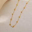VIGO : Collier en chaîne dorée avec perles ovales et rondes, simple et essentiel.