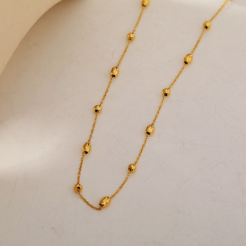 VIGO : Collier en chaîne dorée avec perles ovales et rondes, simple et essentiel.
