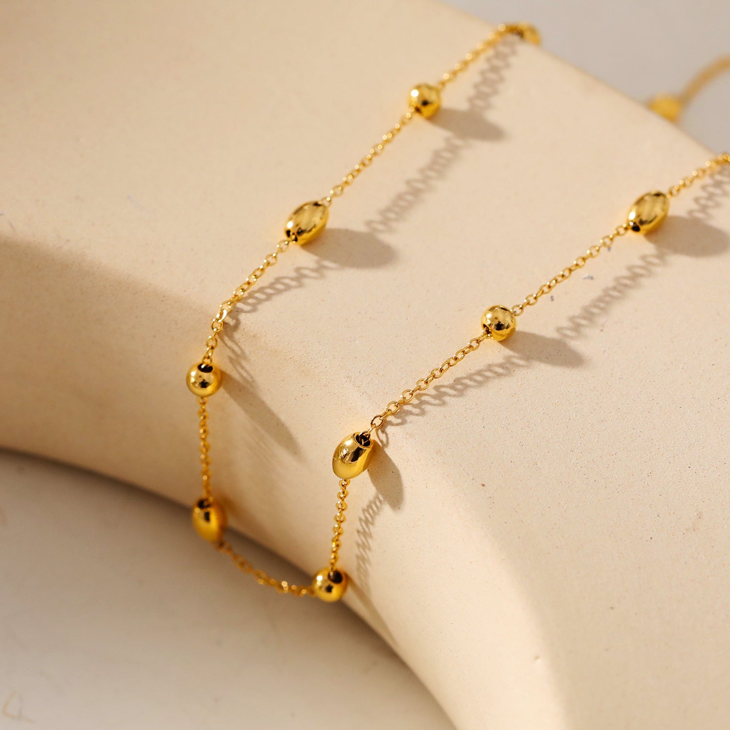 VIGO : Collier en chaîne dorée avec perles ovales et rondes, simple et essentiel.