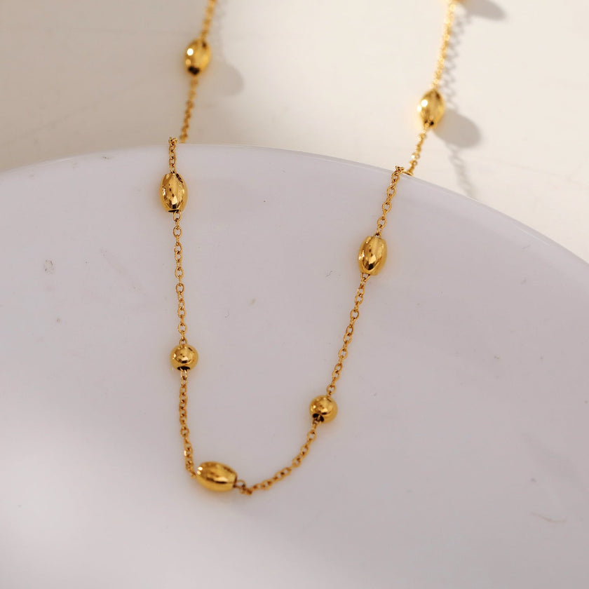 VIGO : Collier en chaîne dorée avec perles ovales et rondes, simple et essentiel.