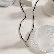 Collier RITA à chaîne perlée noir et argent avec pendentif dent en argent gravé.