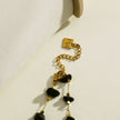 Collier SARA en perles carrées dorées miniatures et pierres naturelles noires.