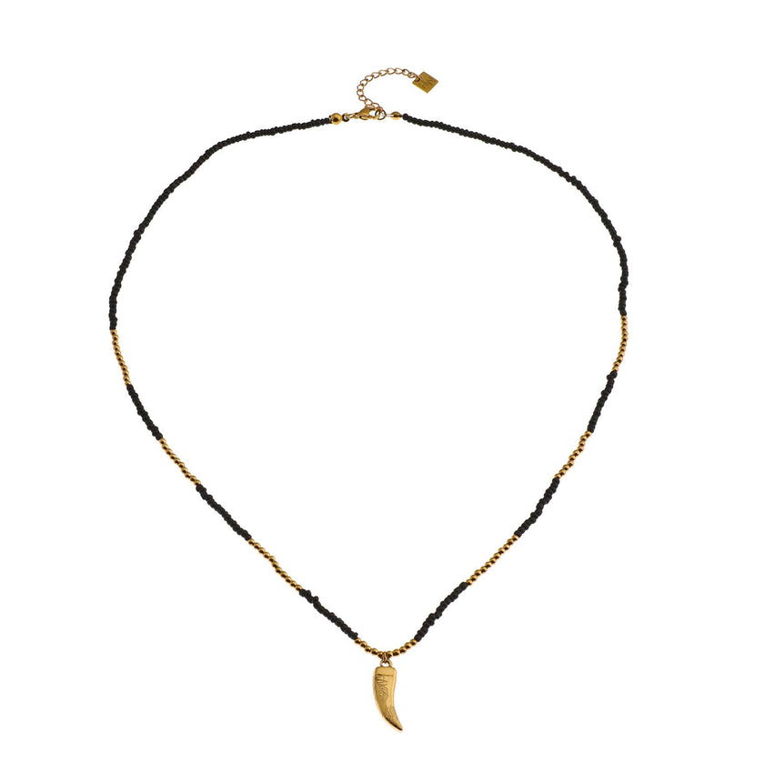 Collier RITA à chaîne perlée noir et or avec pendentif dent en or gravé.