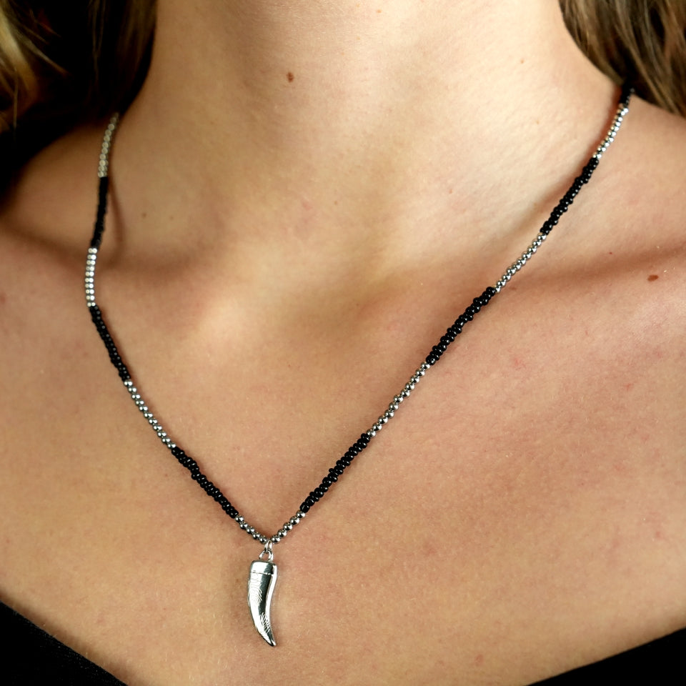 Collier RITA à chaîne perlée noir et argent avec pendentif dent en argent gravé.