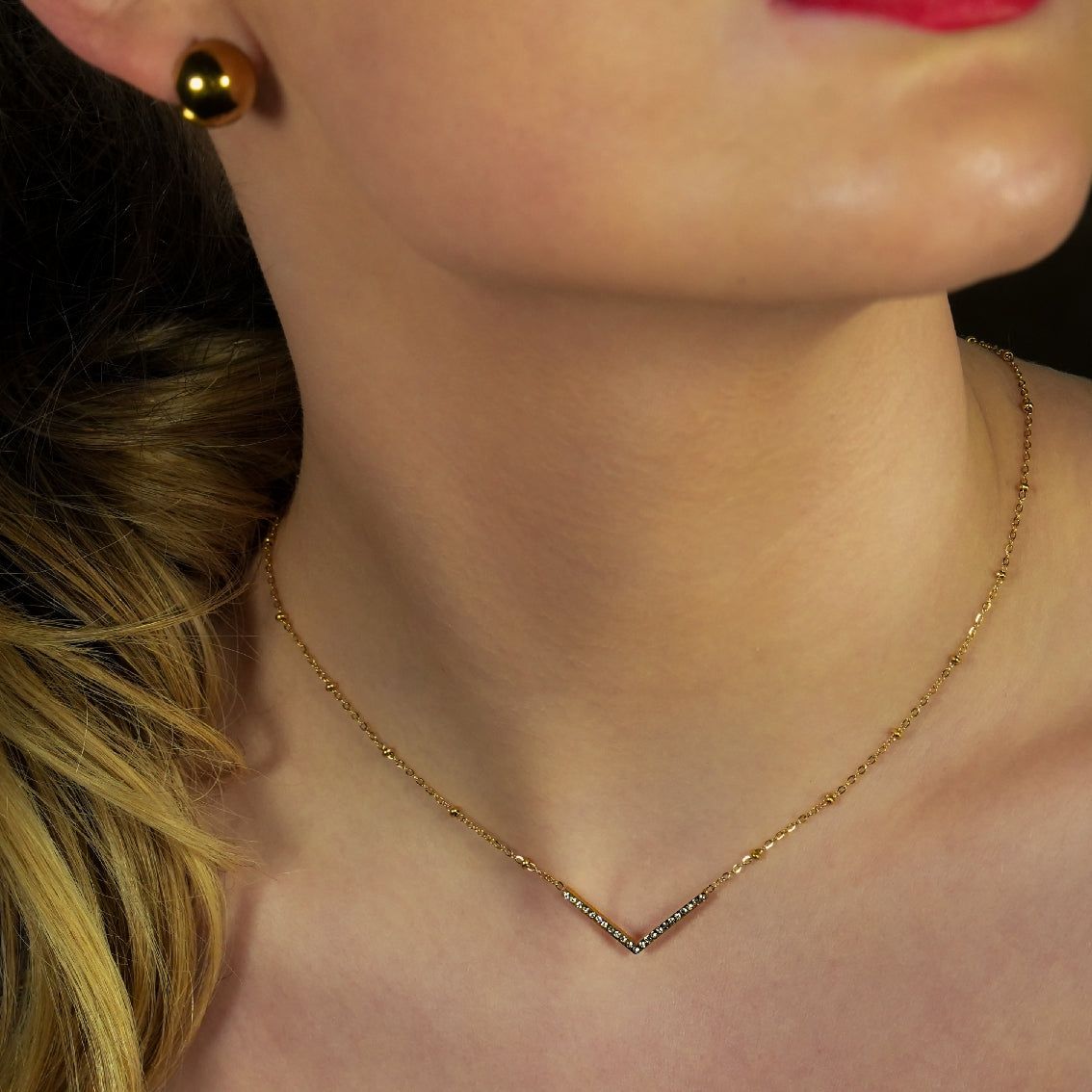 SANITA : Pendentif délicat en forme de « V » serti de zircons, sur chaîne perlée.