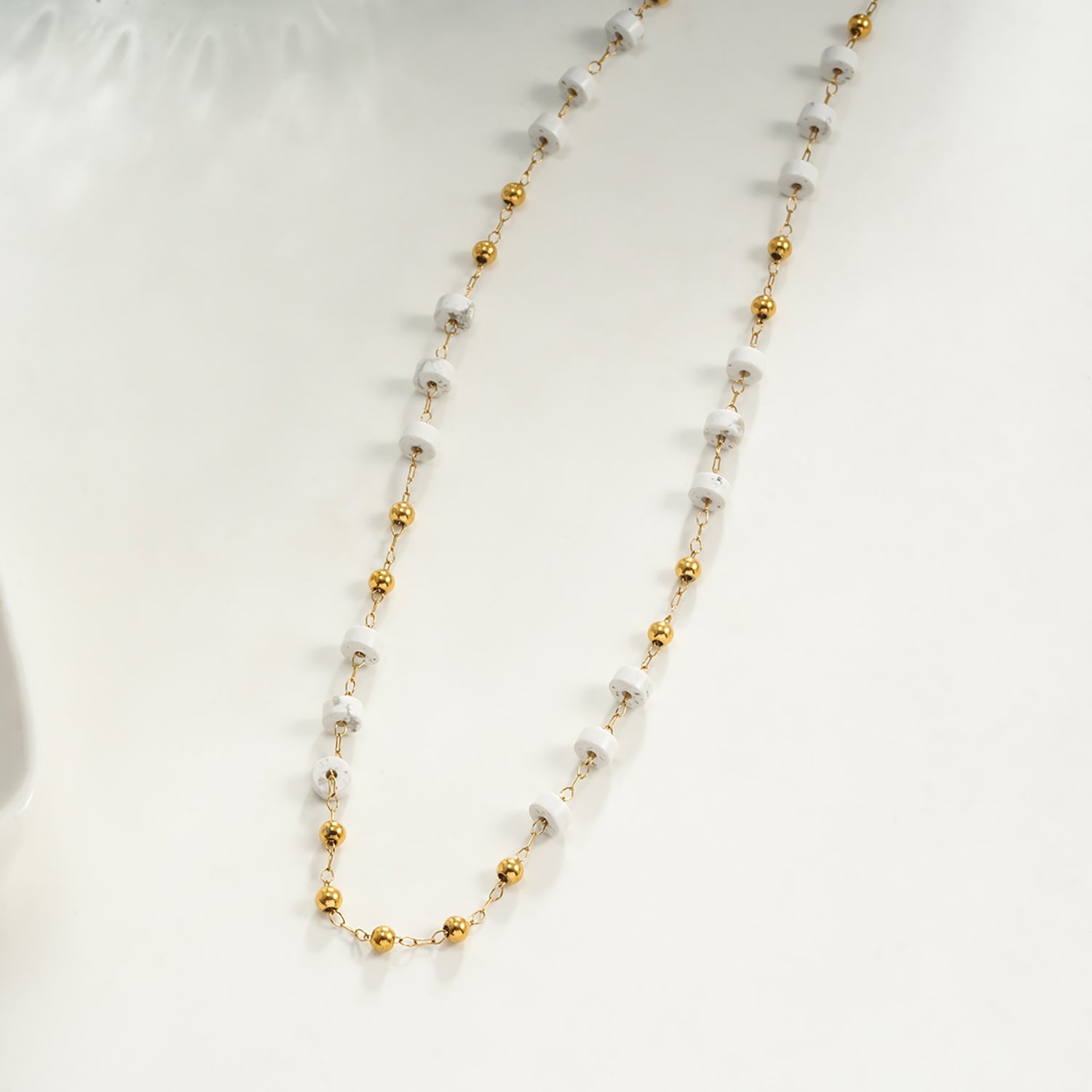 SANTA CRUZ White : Collier chaîne avec perles dorées et pierres blanches.