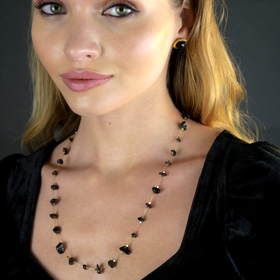 Collier SARA en perles carrées dorées miniatures et pierres naturelles noires.