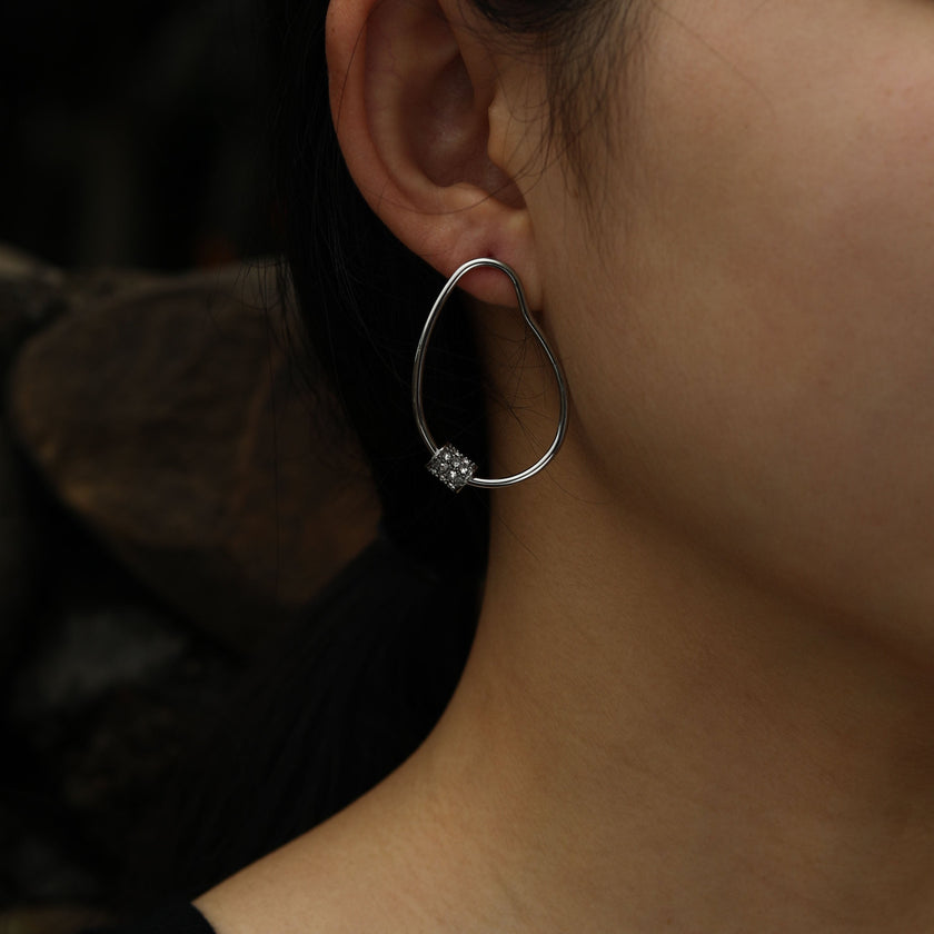 Boucles d'oreilles créoles en argent SIMAN ornées de zirconiums pavés de forme irrégulière.