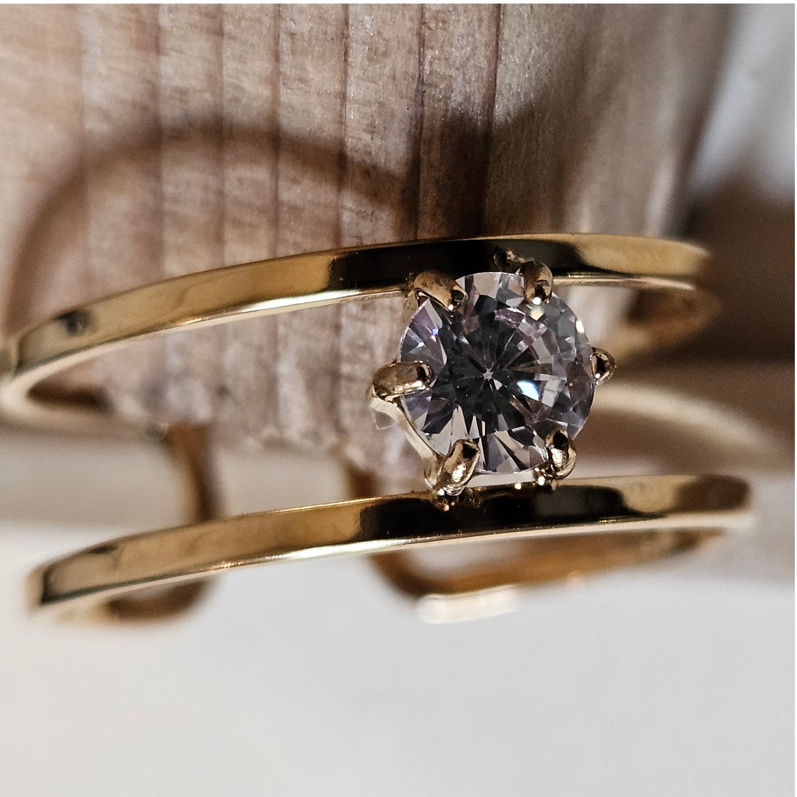 SINTA : Bague minimaliste à double anneau avec zircone solitaire au centre.