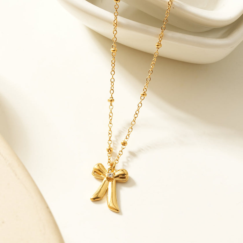 TALIANA Gold : Collier délicat à perles avec pendentif nœud et zircone solitaire – Bijou élégant pour tous les jours